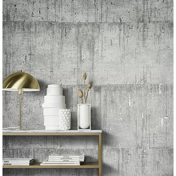 Marburg Natural Opulence Vliestapete - Grau, Betonoptik, 10,05 x 0,7 m - Strukturierte Tapete in Grau und Weiß mit Betonoptik, in einem modernen Wohnraum hinter einem goldenen Konsolentisch.