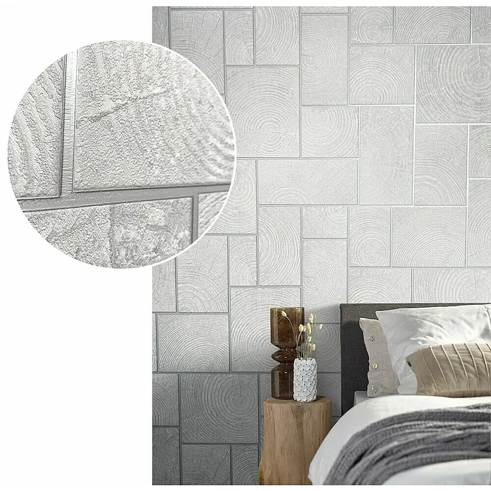 Marburg Natural Opulence Vliestapete - Weiß-Grau, Holzoptik, 10,05 x 0,7 m - Nahaufnahme einer Wand mit einer auffälligen Tapete, die ein Holzklotzdesign in Grau- und Silbertönen zeigt und eine moderne Ästhetik bietet.