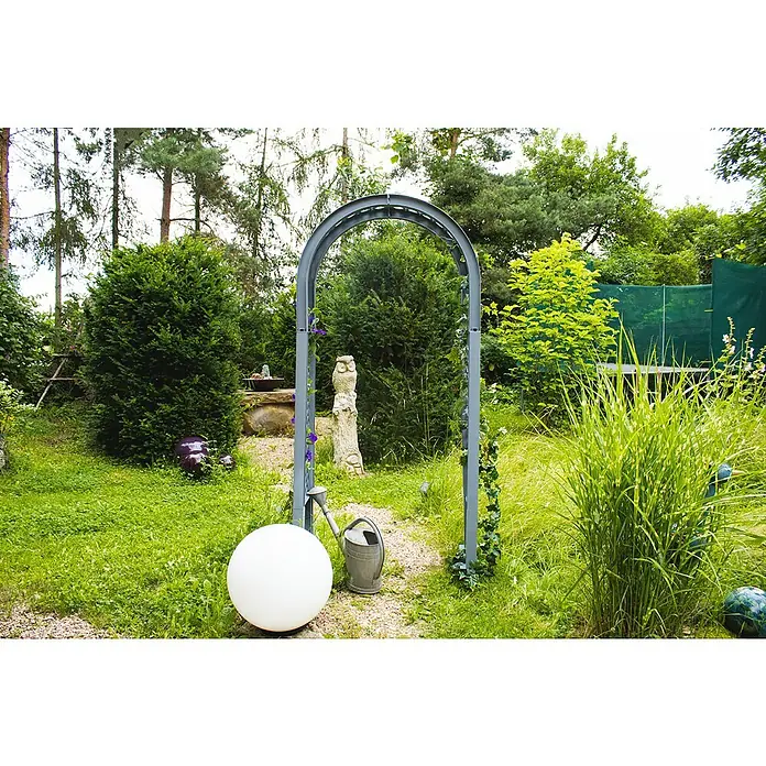 KHW Rosenbogen - Grau, 100 x 43 x 207 cm - Eine Gartenleuchte in Kugelform erhellt einen üppigen Garten, umgeben von Grün und einer malerischen Torbogenstruktur.