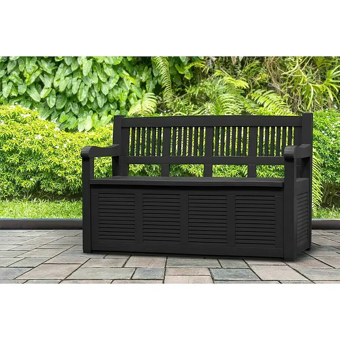Jelenia Plast Gartenbank Salzburg - L x B x H: 130 x 60 x 85 cm, Kunststoff, Anthrazit - Schwarze Gartenbank mit Stauraum vor üppigem Grün.