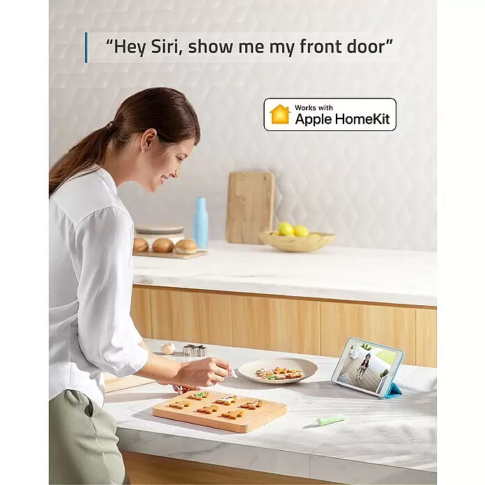 Eufy Türklingel mit Kamera 2K mit Basis T8210 - Schwarz, L x B x H: 111 x 184 x 206 mm - Frau dekoriert Kekse und sieht ihre Haustür live auf einem Tablet. Funktioniert mit Apple HomeKit und Siri.