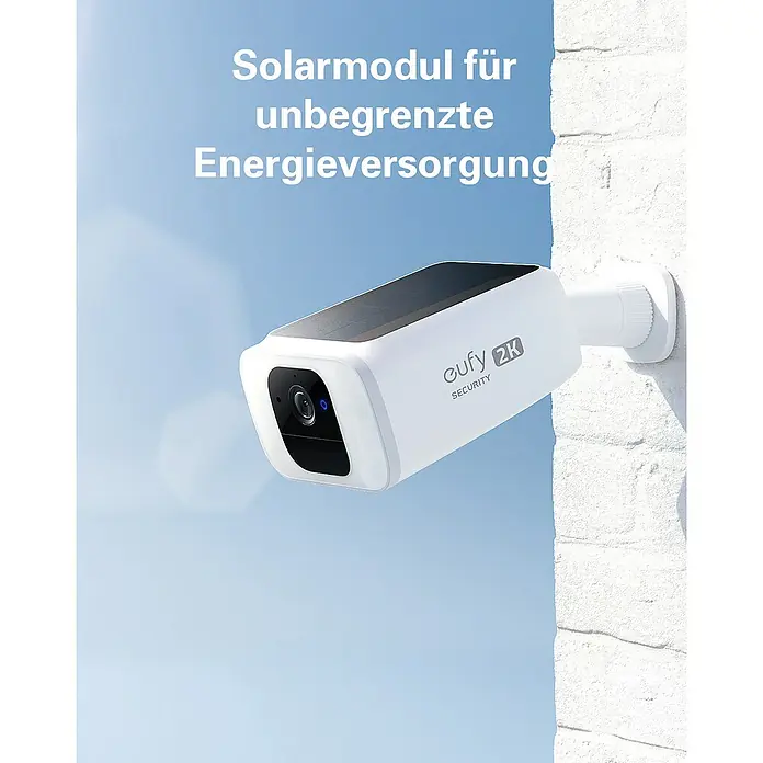 Eufy Überwachungskamera SoloCam S40 T8124 - L x B x H: 172 x 96 x 175 mm - Solarbetriebene Eufy 2K Sicherheitskamera für unbegrenzte Energieversorgung, montiert an einer weißen Ziegelwand mit blauem Himmel im Hintergrund.