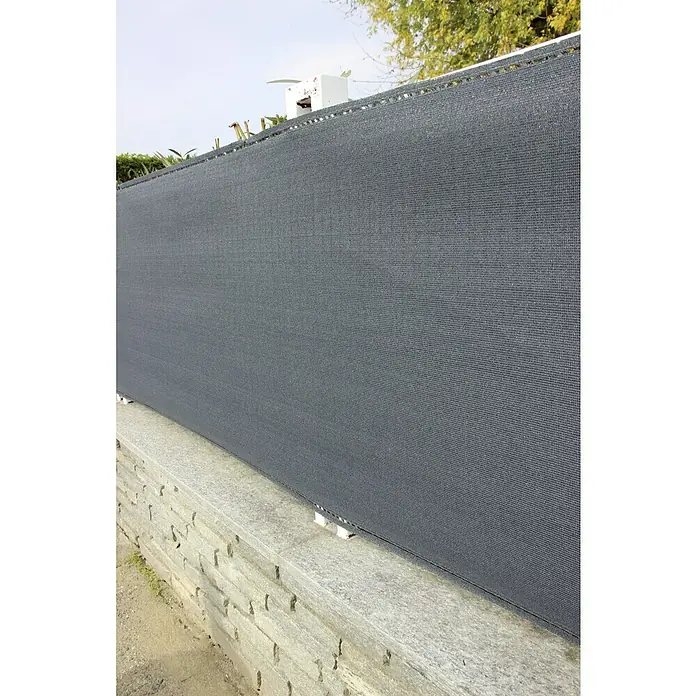 Malla de ocultación Coimbra - 5 x 2 m, Antracita - Imagen de una valla de pantalla de privacidad de tela opaca gris unida a una pared de piedra, que ofrece aislamiento en el jardín o en el patio.