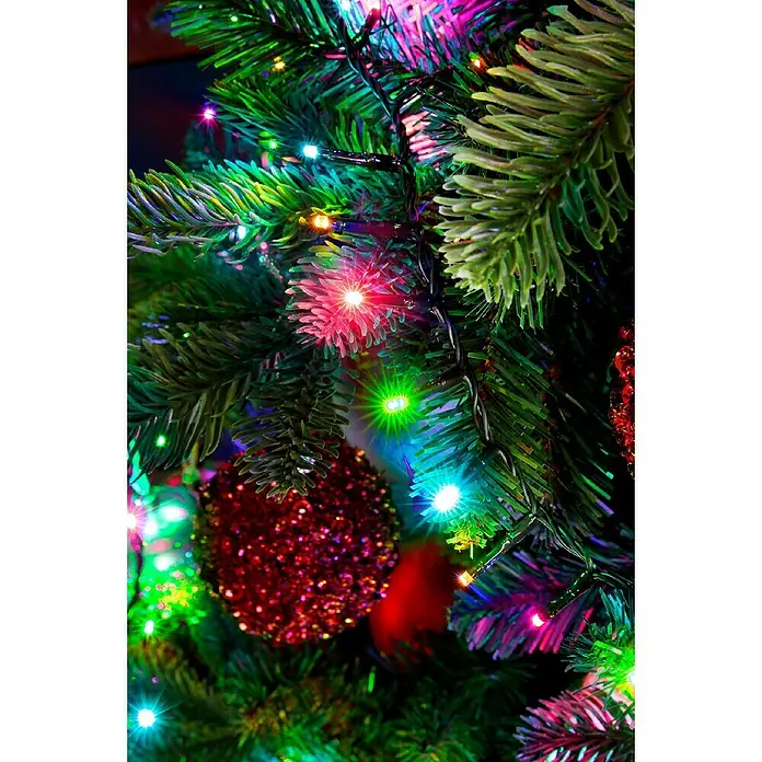 Guirnalda luminosa LED Compact - Para exterior, Color de luz: Multicolor, Número de bombillas: 500 ud., 11 m - Detalle de un árbol de Navidad festivo adornado con luces de colores y bolas rojas brillantes, creando un ambiente navideño alegre.