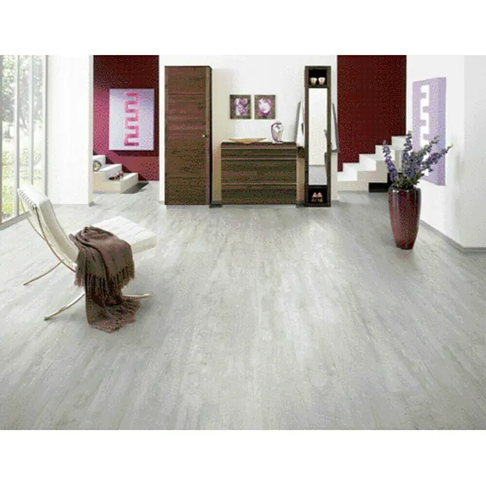 LOGOCLIC Laminado Alabaster Barnwood - 1.285 x 192 x 10 mm, Roble gris claro, AC5 - Interior elegante con suelo de madera clara, muebles marrones y sillón moderno con manta. Ambiente acogedor y elegante.