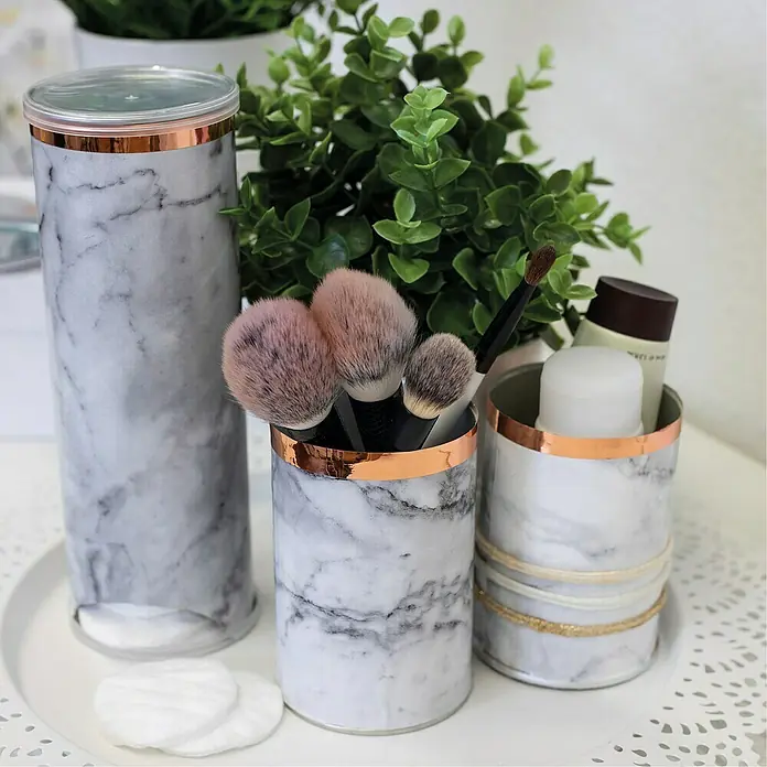 D-c-fix Marmoreffektfolie Romeo - 200 x 45 cm, Weiß-Grau, Selbstklebend - Marmorierte Kosmetikbehälter mit goldenen Akzenten, die Pinsel, Wattepads und Hautpflegeprodukte stilvoll aufbewahren.
