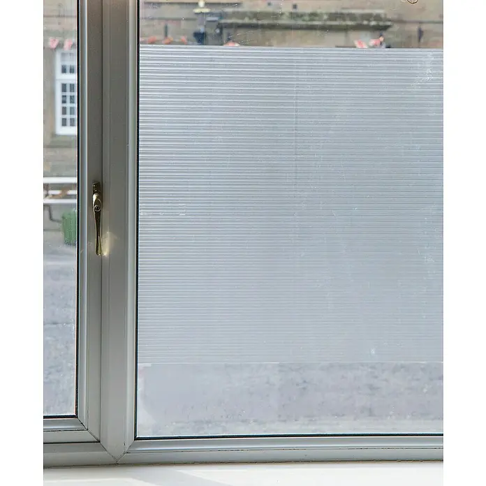 D-c-fix Lámina adhesiva translúcida - An x Al: 45 x 200 cm, Transparente - Primer plano de una ventana con película esmerilada, que proporciona privacidad y filtra suavemente la luz.