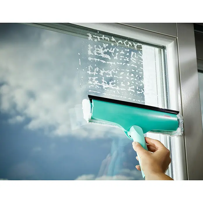 Leifheit Fenster-Wischer Windows & Frame Cleaner L Micro duo - Breite: 32 cm, Kunststoff - Nahaufnahme eines Leifheit Fenstersaugers beim Reinigen einer Fensterscheibe, der strahlende Sauberkeit verspricht.