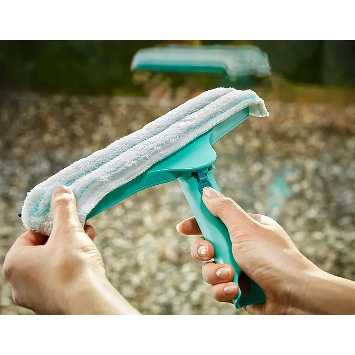 Leifheit Fenster-Wischer Windows & Frame Cleaner L Micro duo - Breite: 32 cm, Kunststoff - Nahaufnahme einer Hand, die einen Fensterwischer mit Mikrofaserpad hält, ideal für die streifenfreie Reinigung von Glasflächen.