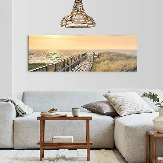 Reinders Decopanel - Way to The Sea, B x H: 156 x 52 cm - Wandbild mit Dünenlandschaft über einem Sofa, das eine entspannende Atmosphäre im Wohnzimmer schafft. Natürliche Farben und gemütliches Design.