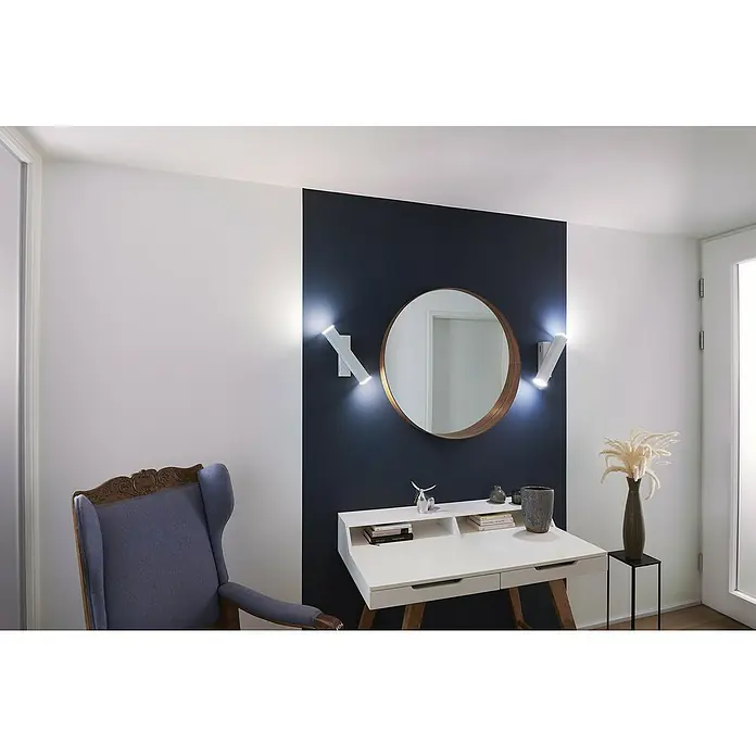 Ledvance LED-Wandleuchte - 12 W, L x B x H: 30,9 x 5 x 10,6 cm, Weiß, Mehrfarbig - Ein stilvolles Interieur mit einem runden Spiegel über einem weißen Schreibtisch, flankiert von modernen Wandleuchten und einem blauen Sessel.