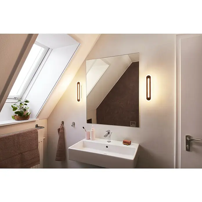 Ledvance Smart+ WiFi LED-Wandleuchte13 W, L x B x H: 30 x 7 x 5 cm, Schwarz, Warmweiß - Elegantes Badezimmer-Interieur mit modernem Waschbecken, stilvollem Spiegel und zwei schlanken Wandleuchten, die ein warmes Licht spenden.