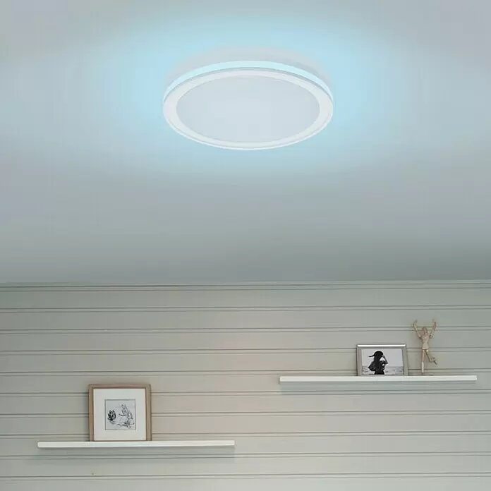 Ledvance LED-Deckenleuchte rund - 28 W, Ø x H: 46 x 9,5 cm, Weiß, Mehrfarbig - Runde weiße Deckenleuchte mit blauem Umgebungslicht in einem Raum mit Täfelung und Regalen.