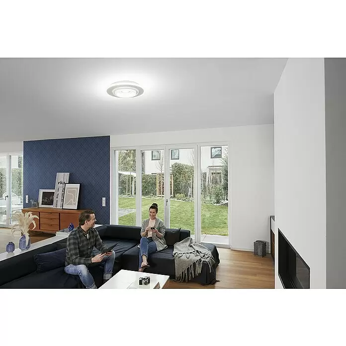Ledvance LED-Deckenleuchte rund - 32 W, Ø x H: 50 x 10 cm, Weiß, RGBW - Weiße, runde LED-Deckenleuchte beleuchtet ein modernes Wohnzimmer, in dem zwei Personen auf einem Sofa entspannen und eine helle Atmosphäre schaffen.
