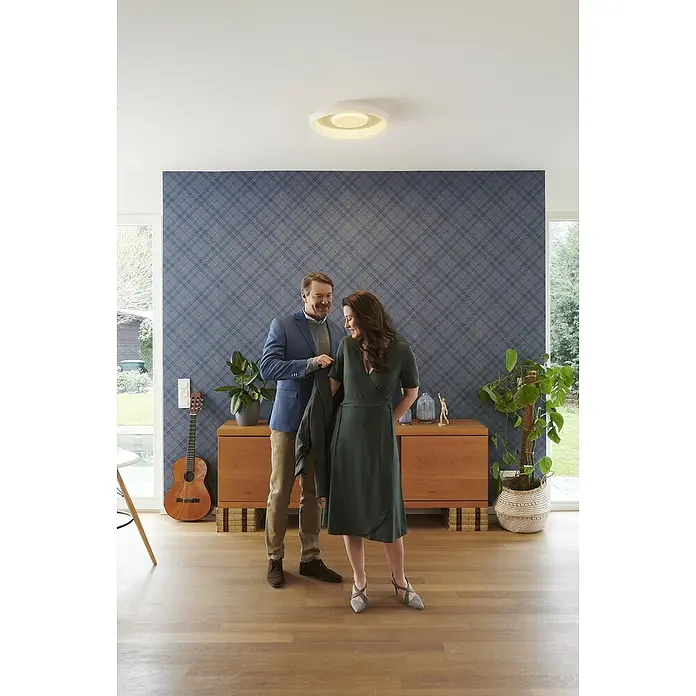 Ledvance LED-Deckenleuchte rund - 32 W, Ø x H: 48,5 x 8 cm, Weiß, Mehrfarbig - Ein Paar steht in einem Raum mit einer modernen Deckenleuchte. Die Lampe ist kreisförmig und gibt ein warmes, einladendes Licht ab.