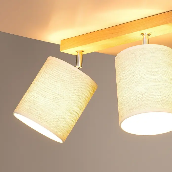Britop Lighting Boho Deckenstrahler - 25 W, L x B x H: 52 x 13 x 25 cm, Eiche, Beige, E27, 2 Stk. - Zwei warm beleuchtete Lampen mit beigen Stoffschirmen und Holzhalterung an einer grauen Decke. Modernes Design für gemütliches Licht.