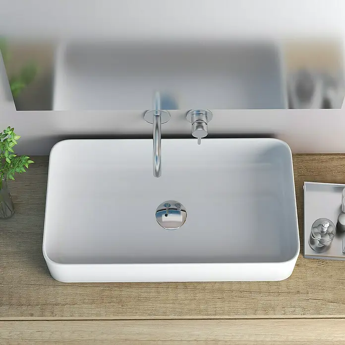 Artysan Lavabo de sobremesa cerámico - 62,5 x 35,5 cm, Blanco - Vista superior de un lavabo rectangular moderno con grifo, desagüe y decoración sobre una mesa de madera.