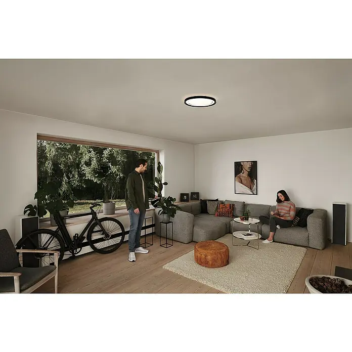 Ledvance Smart+ WiFi LED-Deckenleuchte rund Gavin - 30 W, Ø x H: 48,4 x 8,5 cm, Schwarz, Warmweiß - Eine moderne Deckenleuchte mit runder Form hängt in einem hellen Wohnzimmer und sorgt für angenehmes Licht.