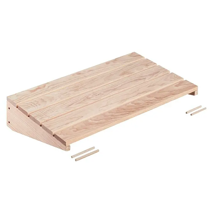 Astigarraga Wally Estante de madera - L x An x Al: 46 x 80 x 13,7 cm, Natural, Madera de pino, Carga límite balda: 100 kg - Un reposapiés de madera está fotografiado sobre un fondo negro. El reposapiés está hecho de madera clara y tiene una forma inclinada.