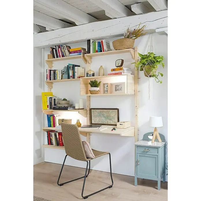 Astigarraga Wally Riel de fijación - L x An x Al: 96 x 4,5 x 4,5 cm, Madera maciza de pino - Estantería de madera con escritorio, libros, decoración y silla en una habitación luminosa. Una lámpara en una mesita azul a la derecha.
