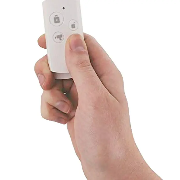 Muvit iO Control remoto para sistema de alarma - Blanco - Una mano sostiene un mando a distancia blanco con cuatro botones que controlan varias funciones de seguridad.