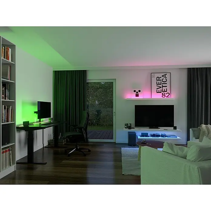Paulmann LED-Band - Länge: 300 cm, Lichtfarbe: RGB, 30 W, 230 V - Ein moderner Wohnraum mit einem Bücherregal, Schreibtisch mit Monitor und einem TV-Bereich, beleuchtet mit farbigen LED-Leuchten.