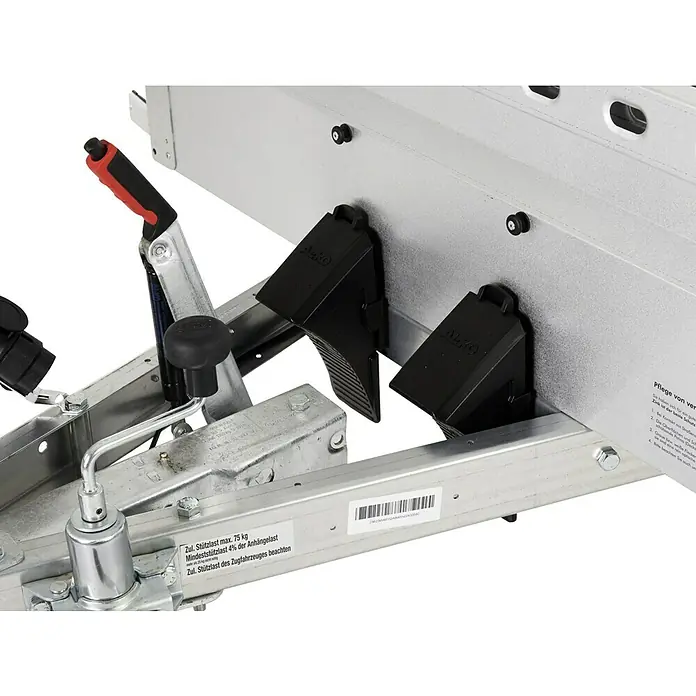 Stema Anhänger BH-R 850 - Nutzlast: 685 kg, Einachser, Kasteninnenmaß: 201 x 108 x 33 cm, Gebremst - Nahaufnahme einer Anhängerkupplung mit Feststellbremse und Unterlegkeilen.