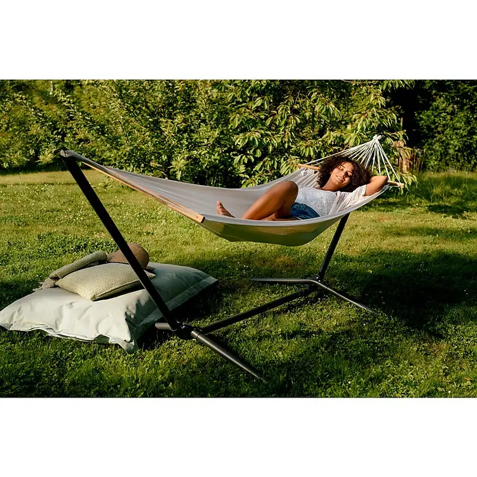 Hängematten-Set mit Gestell - L x B x H: 300 x 105 x 120 cm, Beige - Frau entspannt auf einer Hängematte im Garten. Die Hängematte mit Gestell bietet eine tolle Entspannungsmöglichkeit im Freien.