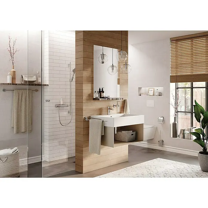 Lenz Seifenspender Vida - L x B x H: 13 x 7,35 x 18,9 cm, Metall, Chrom - Ein modernes Badezimmer mit Waschbecken, Spiegel und Holzelementen für eine warme Atmosphäre. Die Beleuchtung sorgt für ein angenehmes Ambiente.