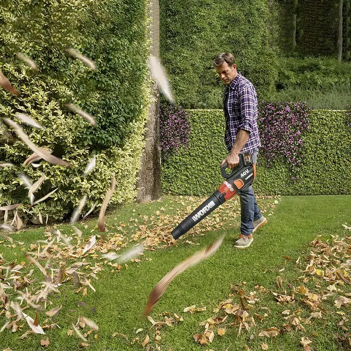 Worx PowerShare 20V Akku-Laubbläser WG584E.9 - 40 V, Ohne Akku - Ein Mann benutzt einen Worx Akku-Laubbläser, um Blätter von einem Rasen zu entfernen. Der Laubbläser ist kabellos und leicht zu bedienen.