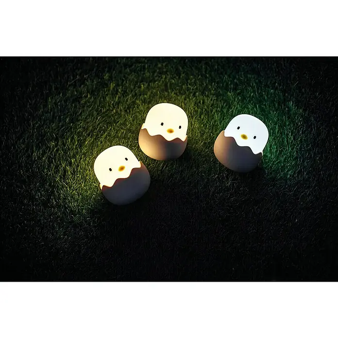 MegaLight LED-Nachtlicht EGGY EGG - Weiß/Rosa/Gelb, L x B x H: 10 x 10 x 12 cm, RGBW, EGGY EGG - Drei Küken-Nachtlichter auf Gras. Die Lichter haben ein warmes, beruhigendes Leuchten und stehen auf einer Rasenfläche im Freien.