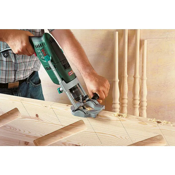 Wolfcraft Bohrständer Tec-Mobil - Schwenkbar bis ± 45° - Mann bohrt mit einer Bosch Bohrmaschine und Führungshilfe Löcher in ein Holzbrett für Spindel Montage.