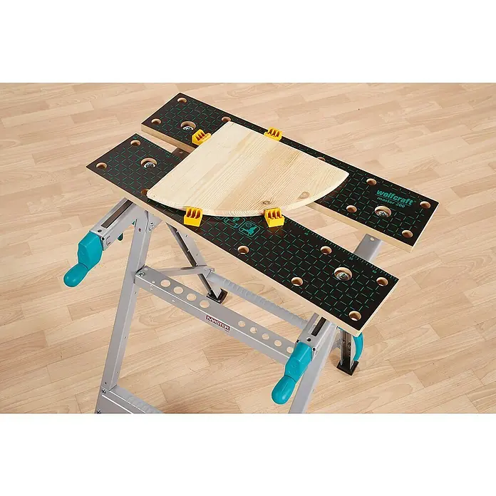 Wolfcraft Master Werkbank Master 200 - Arbeitshöhe: 800 mm, Belastbarkeit: 180 kg - Wolfcraft Master 200 Werkbank mit einer Holzplatte und gelben Klemmen darauf.