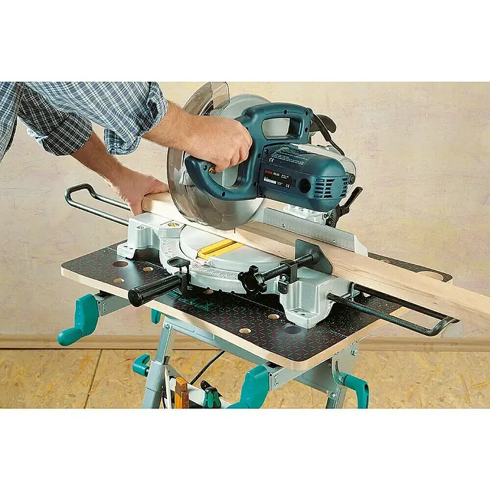 Wolfcraft Master Werkbank Master 600 - Arbeitshöhe: 950 mm, Belastbarkeit: 120 kg - Eine Kappsäge schneidet ein Holzbrett auf einer Werkbank, bedient von einer Person in einem blau karierten Hemd.