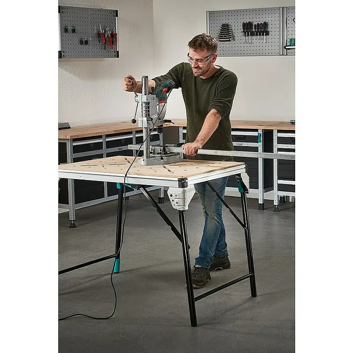 Wolfcraft Soporte de taladro - L x An x Al: 307 x 203 x 570 mm, Apertura máxima: 60 mm - El banco de trabajo Wolfcraft Master en acción: Un hombre utiliza un taladro de columna en este banco robusto y plegable.