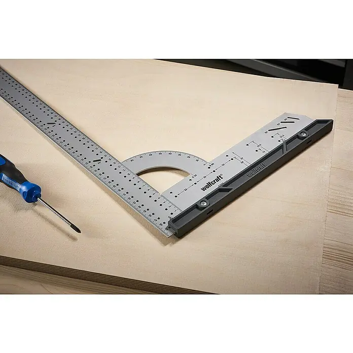 Wolfcraft Universalwinkel - 300 x 200 mm, 90 °, Wechselbarer Anschlag - Das Bild zeigt einen Winkelmesser von Wolfcraft, der auf einem Holzbrett liegt, zusammen mit einem Schraubenzieher.