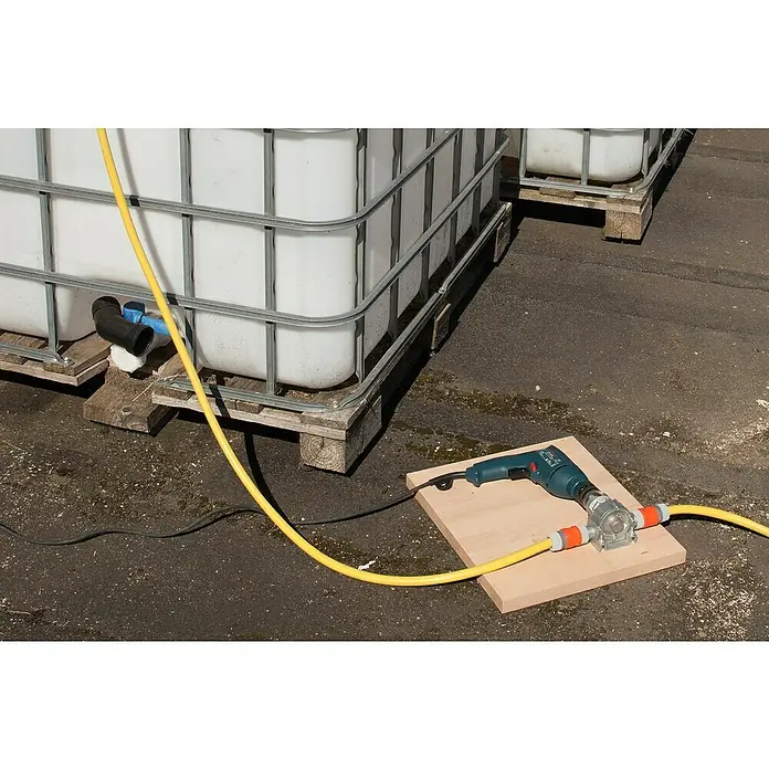 Wolfcraft Pumpe - 3.000 l/h, Förderhöhe: 24 m - 30 m, Metall - Eine Bohrmaschine ist an eine Wasserpumpe angeschlossen, die wiederum mit einem gelben Schlauch verbunden ist, um Wasser aus großen Behältern zu fördern.