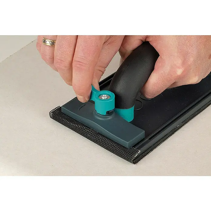 Wolfcraft Handschleifer-Set - Glätten von Flächen, 5 -tlg., Maße Schleifpapier: 280 x 115 mm - Detailaufnahme eines Handschleifers mit Schleifgitter, der von einer Hand bedient wird. Das Werkzeug ist für Schleifarbeiten konzipiert.