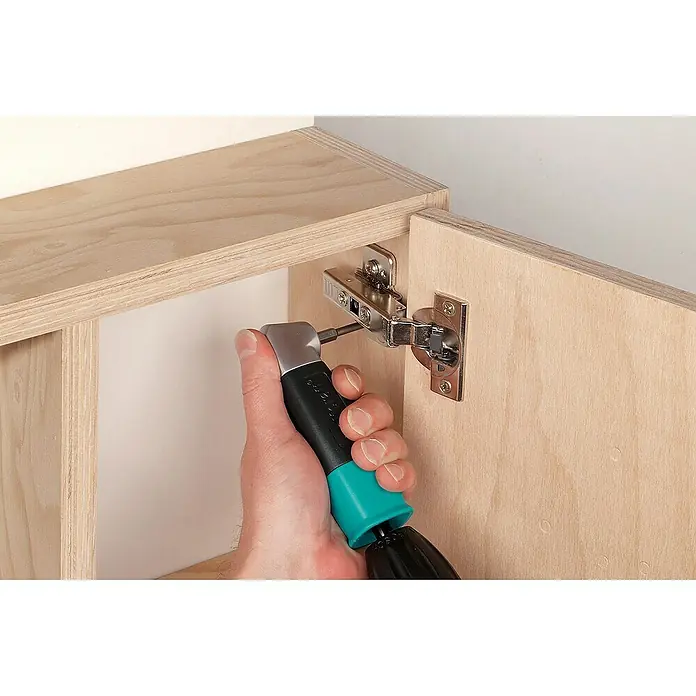 Wolfcraft Winkelgetriebe - Durchmesser Schaft: ¼″ Hex, Max. Drehzahl: 400 U/min - Ein Scharnier wird mit einem Schraubenzieher an einem Holzschrank befestigt. Präzises Werkzeug für Möbelmontage im Detail.