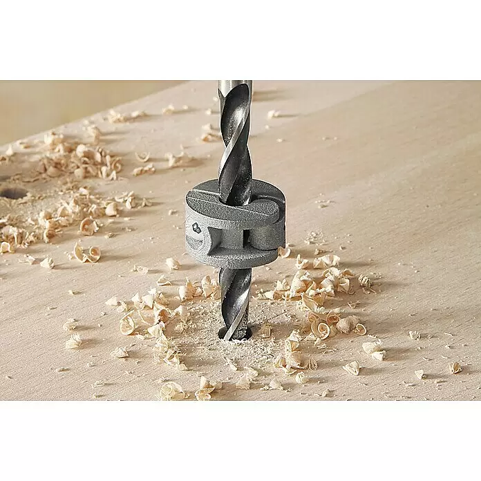 Wolfcraft Tiefenstopp-Set - 4 -tlg. - Grauer Tiefenanschlagring an einem Bohrer, der ein Loch in helles Holz bohrt, umgeben von Spänen.