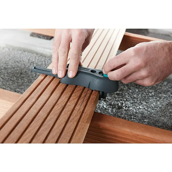 Wolfcraft Terrassenbau-Set - 11 -tlg. - Das Bild zeigt einen Wolfcraft Dielenverleger in Aktion, der für präzise und gleichmäßige Abstände beim Verlegen von Terrassendielen sorgt.