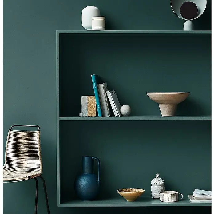 Jotun Esmalte Majestic Radiant - 750 ml, Satinado, Base Amar - Fotografía de una estantería verde con objetos decorativos como jarrones, libros y cuencos, creando un ambiente sereno y elegante.