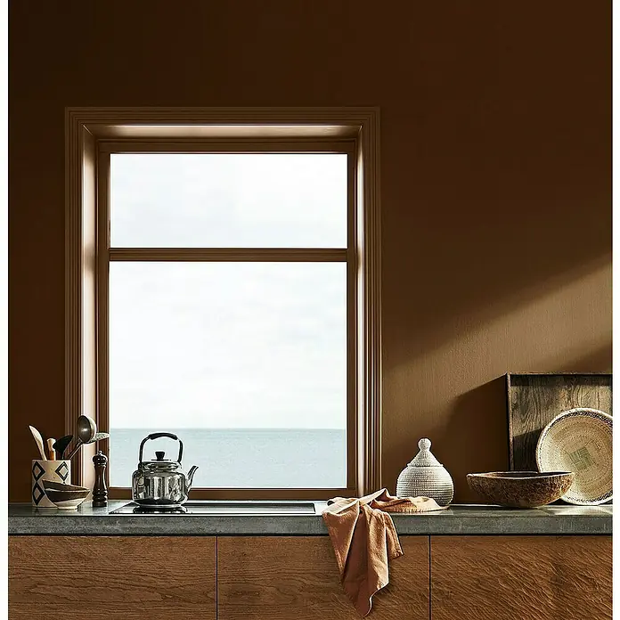 Jotun Esmalte Majestic Radiant - 750 ml, Satinado, Base Amar - Vista de la cocina con ventanas con vista al mar, complementada con platos y utensilios expuestos en la encimera.