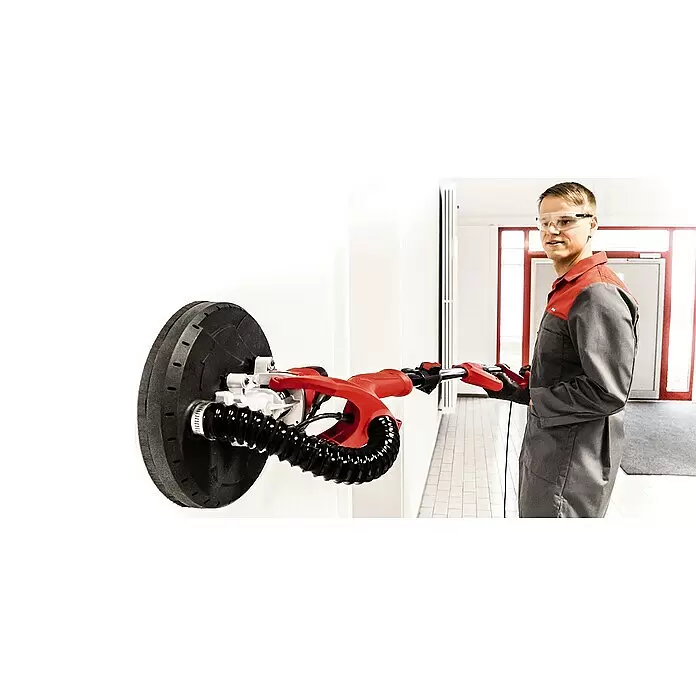 Einhell Wand- & Deckenschleifer TC-DW 225 - 600 W, Durchmesser Schleifscheibe: 225 mm - Mann bedient roten und schwarzen Langhalsschleifer mit rundem Schleifteller an Wand.