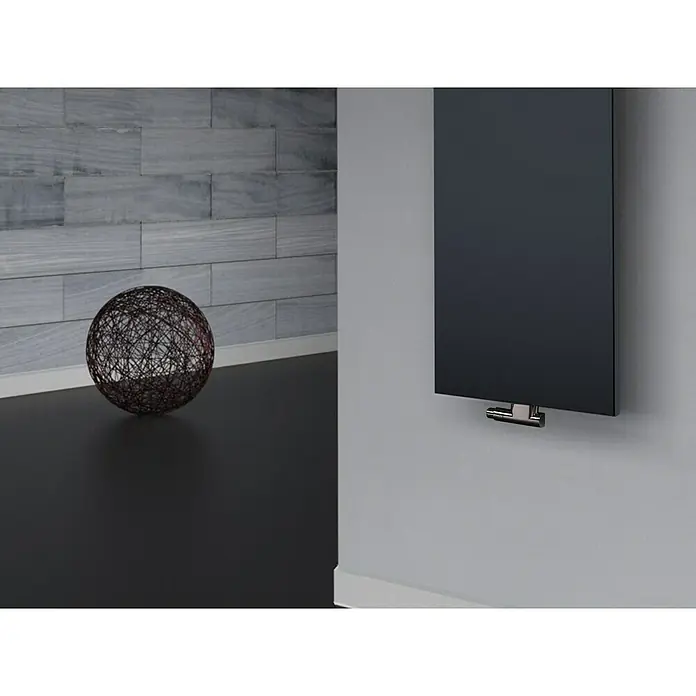 Szagato Designheizkörper Manhattan 2 - B x H: 470 x 1.200 mm, Wärmeleistung bei Vorlauftemperatur von 75 °C (D: 50): 799 W, Anthrazit, Mit 1 Handtuchhalter (50 mm) - Ein eleganter, schwarzer Paneelheizkörper an einer Wand montiert, neben einer dekorativen Kugel. Die Heizung besticht durch ihr schlankes Design.