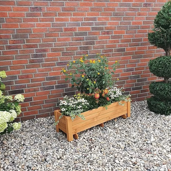 Promadino Pflanzkasten Romantica - Außenmaß (L x B x H): 118 x 38 x 34 cm, Holz, Honigbraun - Heller Pflanzkasten aus Holz, gefüllt mit bunten Blumen, auf Kiesgrund.