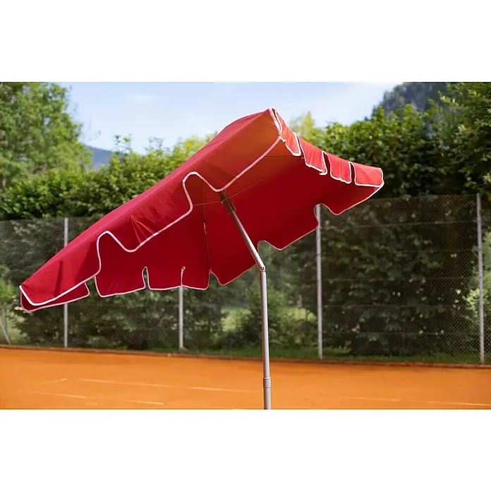 Sunfun Balkonschirm Messina II - Chili, Bespannungsmaß (L x B): 180 x 120 cm - Roter Sonnenschirm mit weißem Rand auf einem Tennisplatz, der Schutz und Schatten an einem sonnigen Tag bietet.