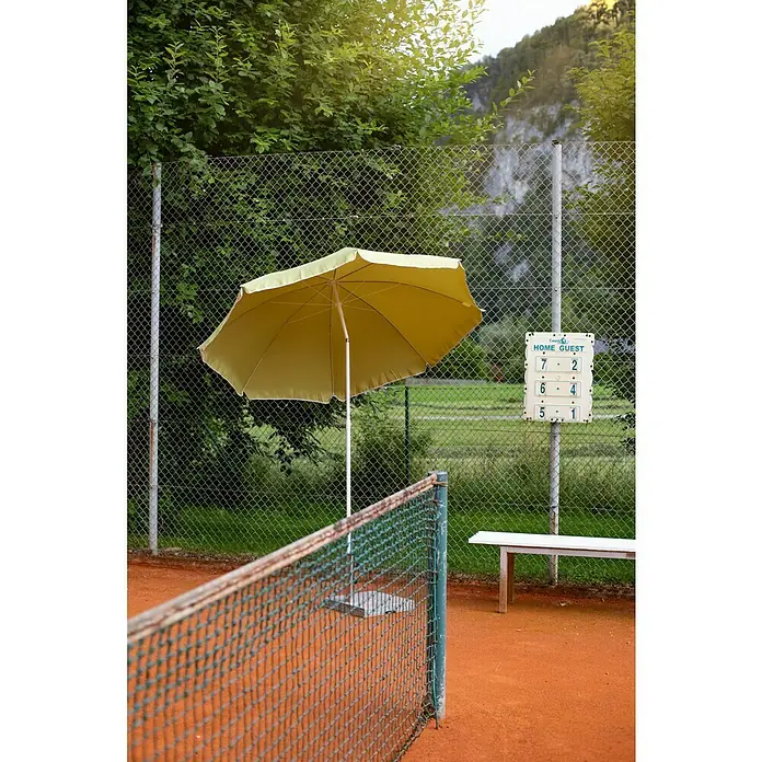 Sunfun Balkonschirm rund Provence II - Apfelgrün, Durchmesser Bespannung: 200 cm - Gelber Sonnenschirm auf einem Tennisplatz.