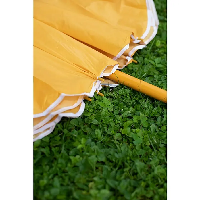 Sunfun Strandschirm - Gelb/Orange, Durchmesser Bespannung: 180 cm - Nahaufnahme eines gelben Sonnenschirms auf grüner Wiese, der ein Gefühl von Sommerfrische und Schutz vor der Sonne vermittelt.