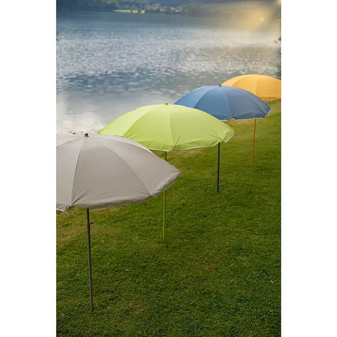 Sunfun Strandschirm - Gelb/Orange, Durchmesser Bespannung: 180 cm - Farbige Sonnenschirme stehen auf einer grünen Wiese am Ufer eines Sees und bieten Schutz vor der Sonne.